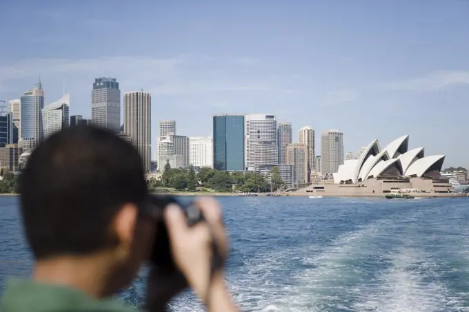 A tourist photographing sydney opera house