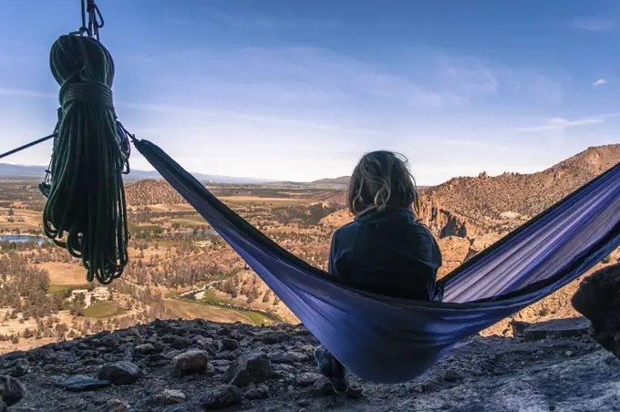 Rock climber on hammock on summit, Smith Rock State Park, Oregon, USA