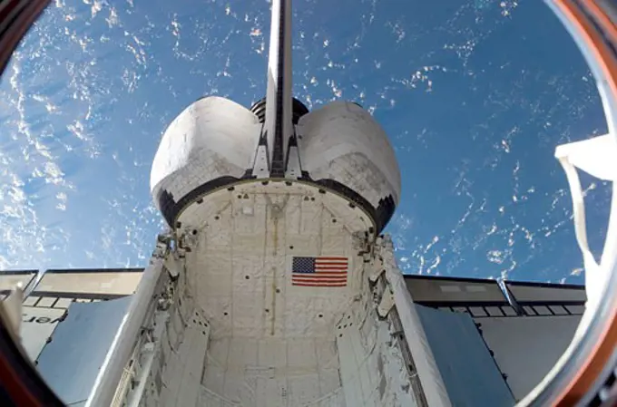 Space Shuttle Discovery on mission STS-120 docked to the International Space Station with the Earth in the background