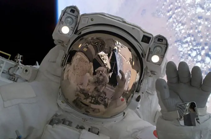 Aerospace Exploration Agency astronaut waving at his spacewalking crewmate