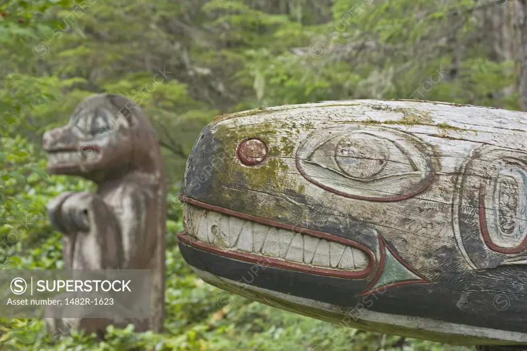 Totem poles of a killer whale and a black bear in a forest, Kasaan Totem Park, Tongass National Forest, Alaska, USA