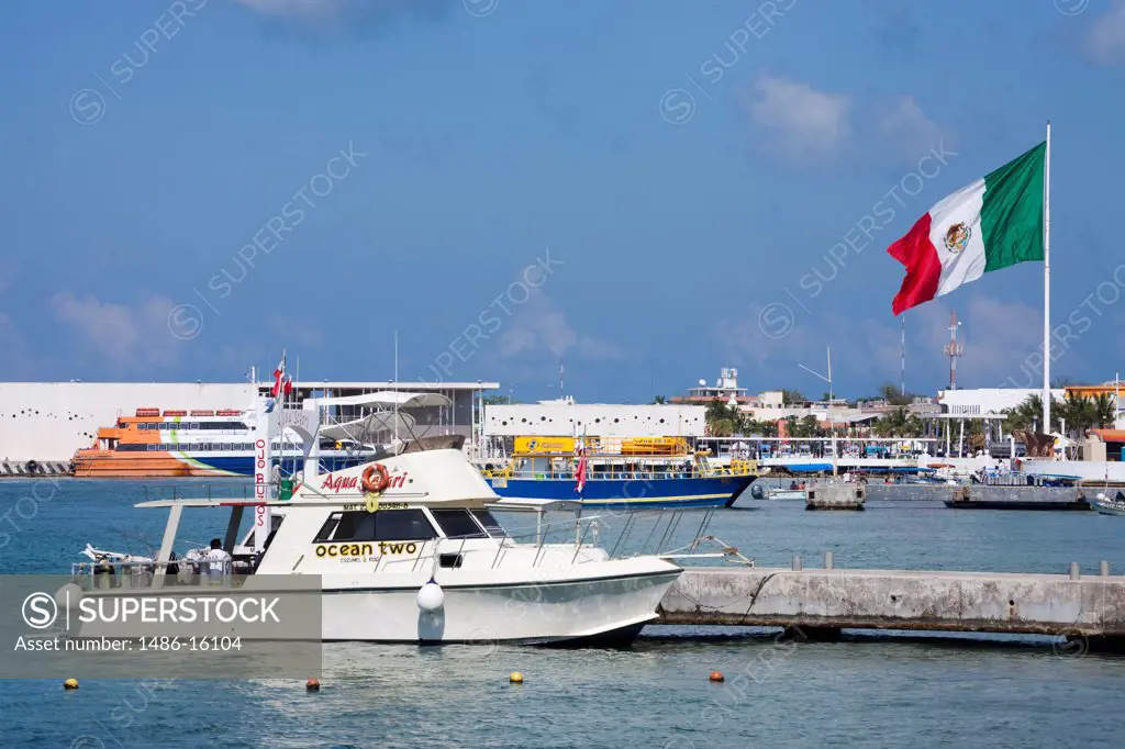 Boats at a pier with Mexican flag in the background, San Miguel, Cozumel, Quintana Roo, Yucatan Peninsula, Mexico