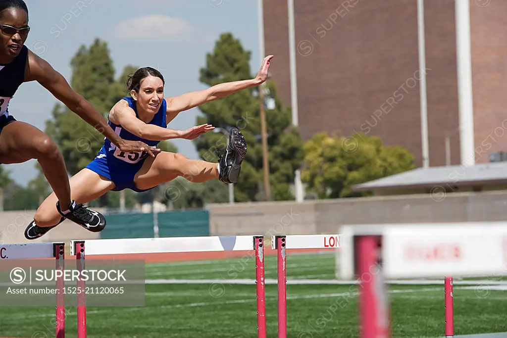 Female athletes hurdling