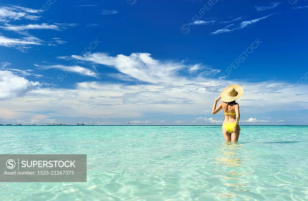 Girl on a tropical beach with hat