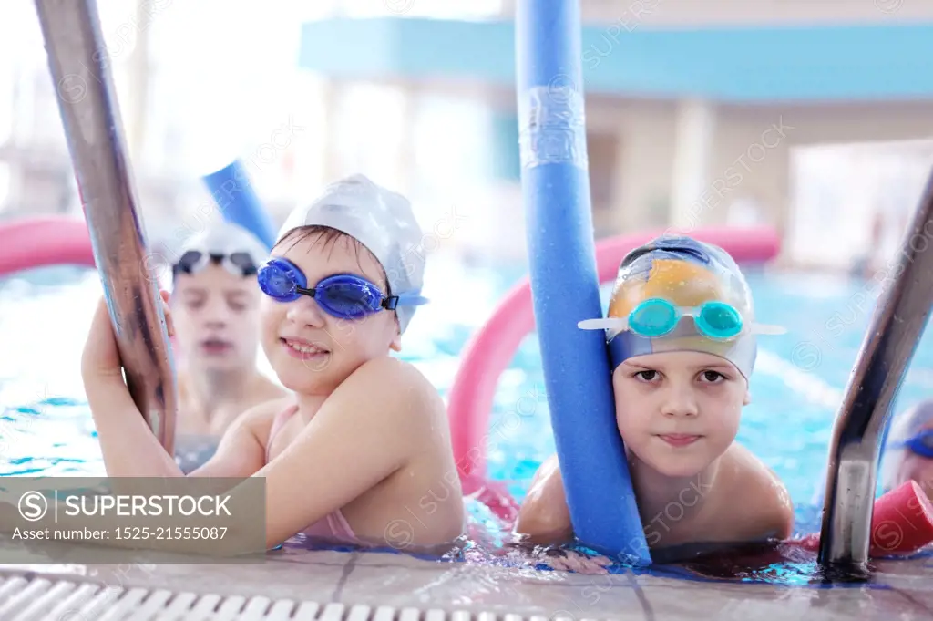 happy children kids group  at swimming pool class  learning to swim