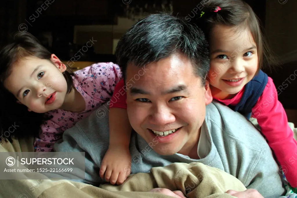 Asian Dad Playing With His Daughters