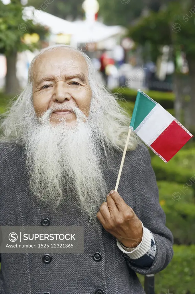 Portrait of a senior man holding a Mexican flag