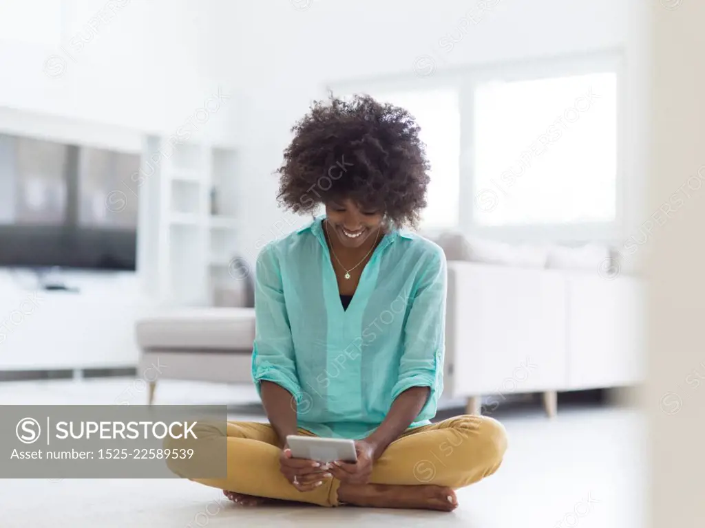 beautiful young black women using tablet computer on the floor at home