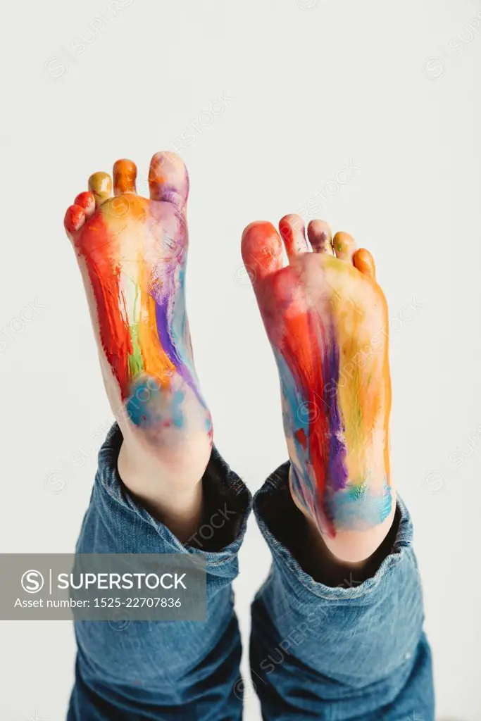 Kids feet painted in rainbow colors. Messy fun. Creative activity.. Kids feet painted in rainbow colors.