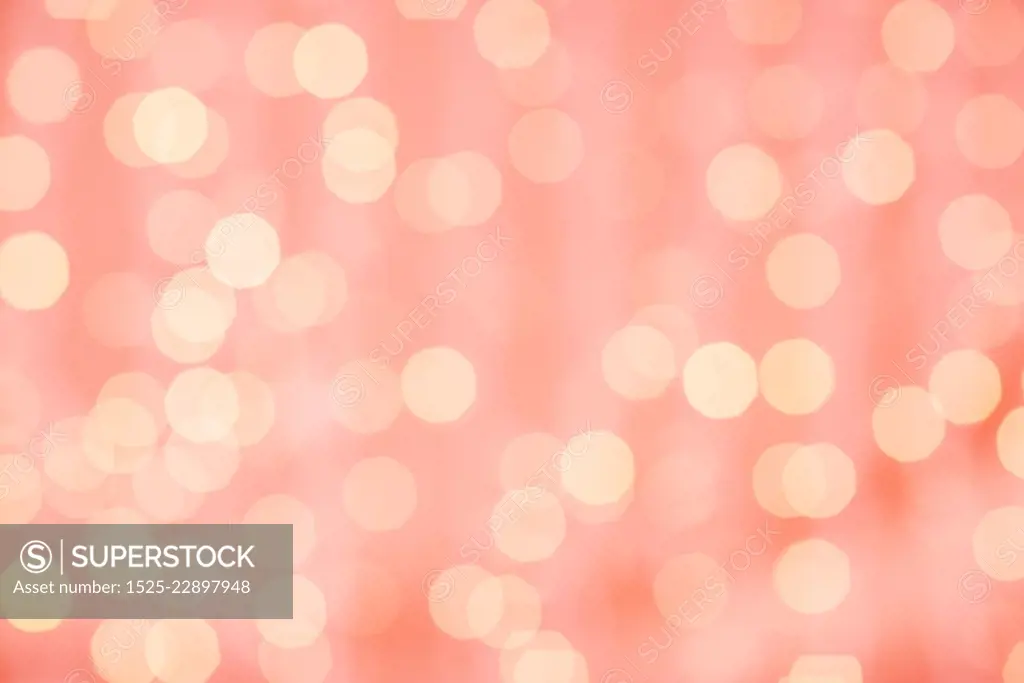 holidays and design concept - blurred bokeh lights in living coral, color of the year 2019. blurred bokeh lights in living coral color