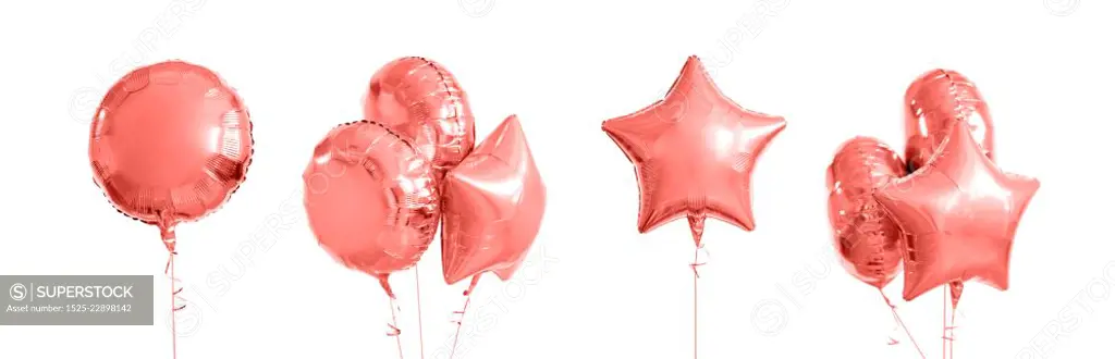 holidays and birthday party decoration concept - many metallic gold helium balloons of different shapes in trendy color of the year 2019 living coral. pink metallic gold helium balloons on white