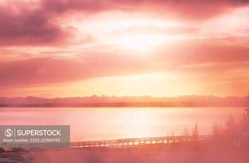 Inspiring natural background. Wooden boardwalk along geyser fields  in Yellowstone National Park, USA. Living coral color toning.