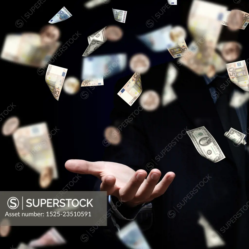 Dreaming to become rich. Hand of businessman standing in the rain of money banknotes