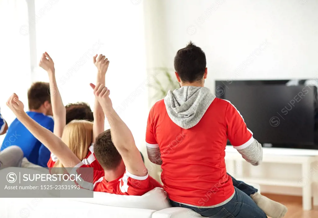 friendship, leisure, sport, people and entertainment concept - happy friends or football fans watching soccer on tv and celebrating victory at home