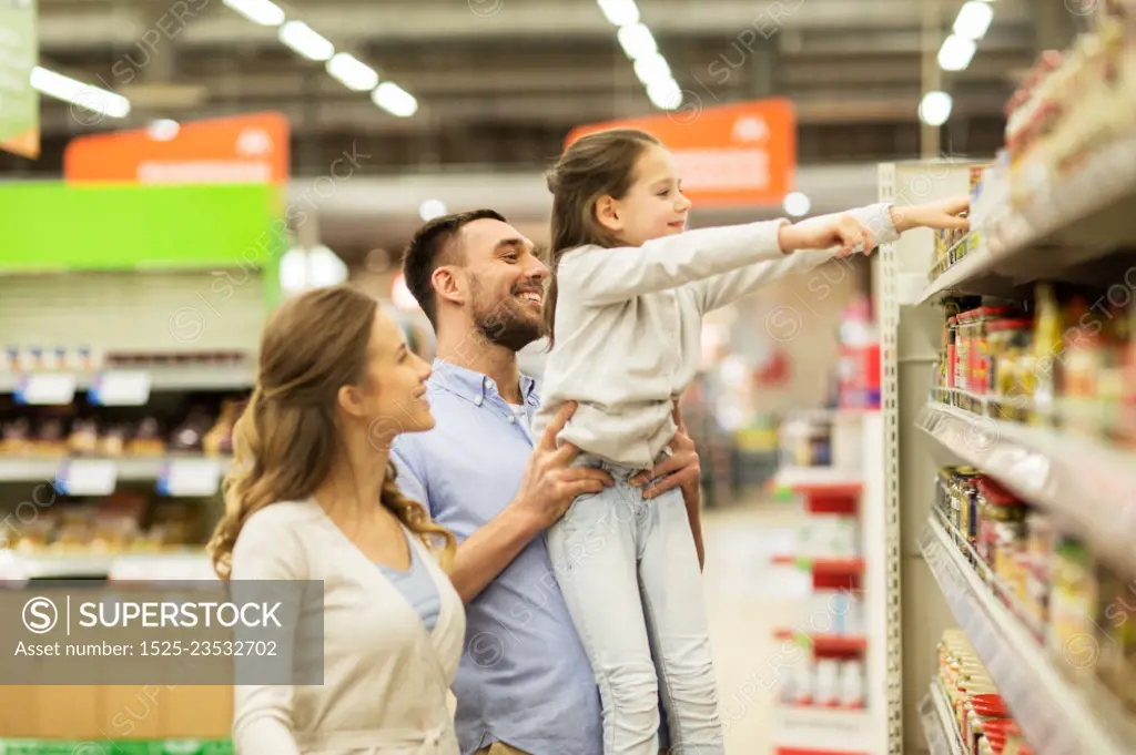 sale, shopping, consumerism and people concept - happy family with child buying food at grocery store or supermarket