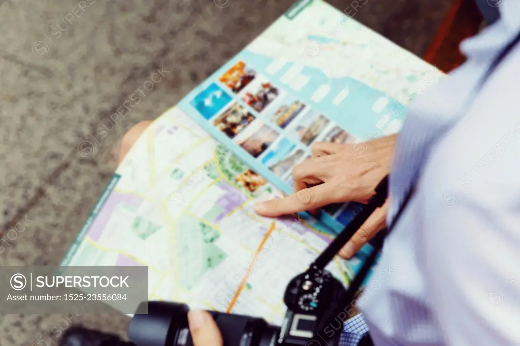 Male tourist in city. Happy male tourist in city with camera and map