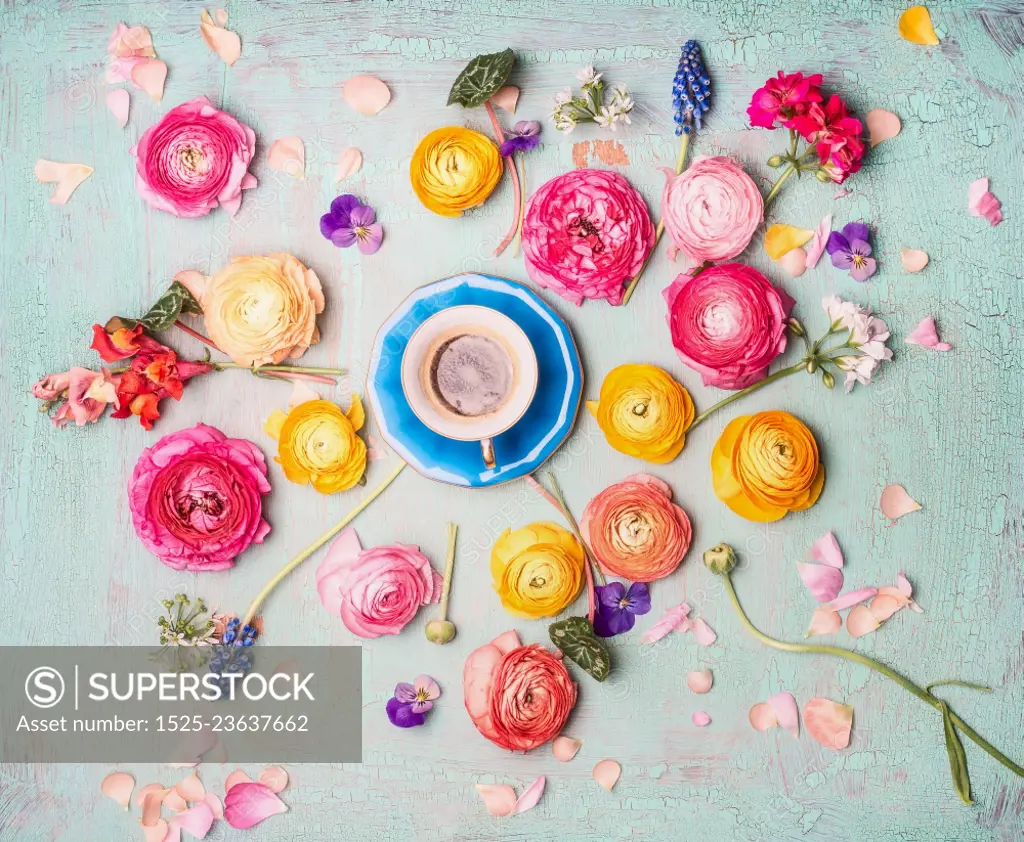 Cup of coffee with colorful flowers on turquoise blue shabby chic background, top view, flat lay