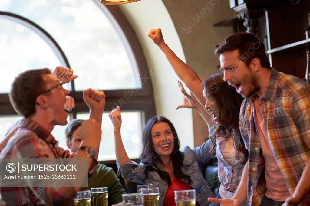 sport, people, leisure, friendship and entertainment concept - happy football fans or friends drinking beer and celebrating victory at bar or pub. football fans or friends with beer at sport bar