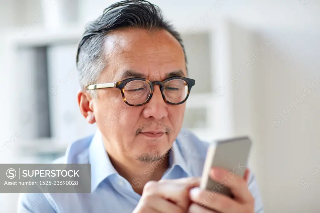 business, people, communication and technology concept - close up of businessman texting on smartphone at office. businessman texting on smartphone at office