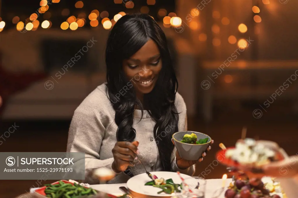 holidays, party and celebration concept - happy woman having christmas dinner and eating at home. happy woman having christmas dinner at home