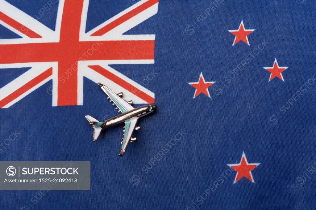 The plane over the flag of New Zealand, the concept of travel. Toy plane on the flag as a background.. The plane over the flag of New Zealand, the concept of travel.