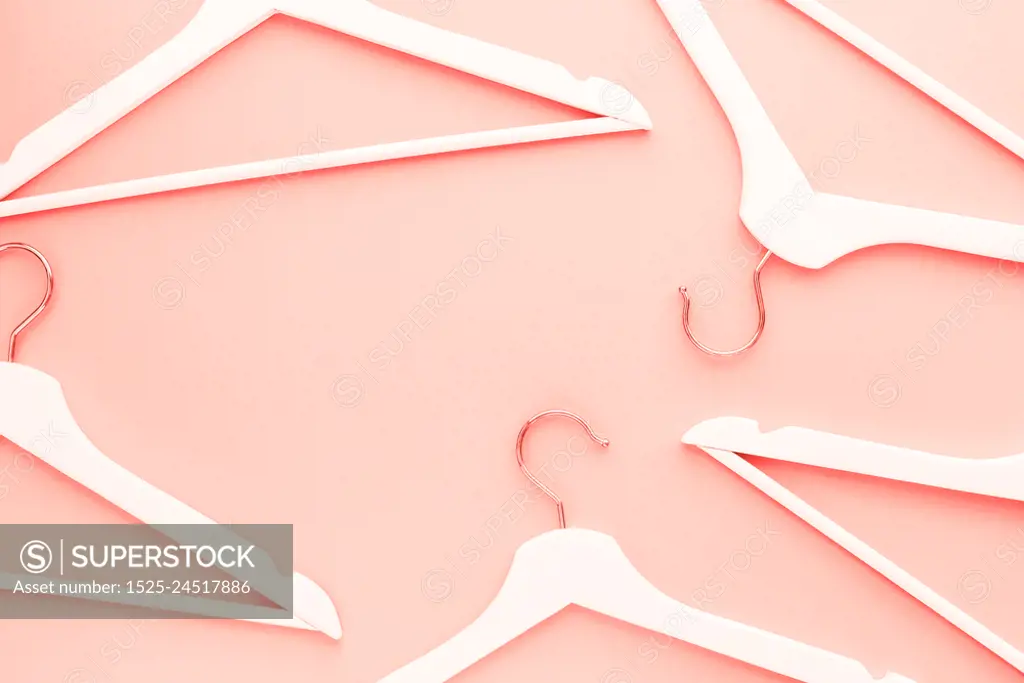 Creative top view flat lay wooden hangers toned living coral color of the year 2019 background copy space minimalism style. Template fashion blog social media sale store promo design shopping concept