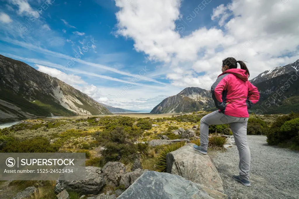 Woman traveller traveling in wilderness landscape of Mt Cook National Park. Mt Cook, the highest mountain in New Zealand,is known for scenic landscape, outdoor travel inspiration, mountain trekking.