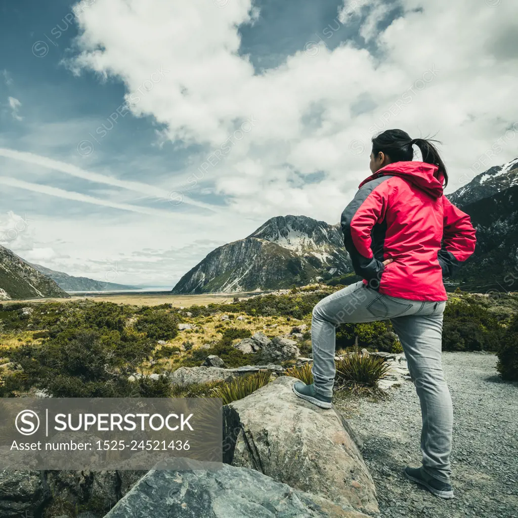 Woman traveller traveling in wilderness landscape of Mt Cook National Park. Mt Cook, the highest mountain in New Zealand,is known for scenic landscape, outdoor travel inspiration, mountain trekking.