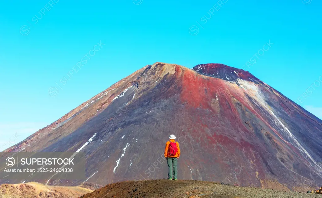 Man walking on hike trail route with New Zealand volcano,  Tramping, hiking, travel in New Zealand.