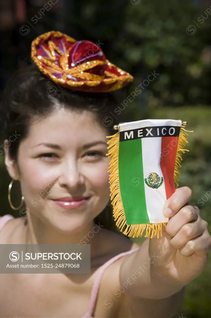 Young woman holding up Mexican flag