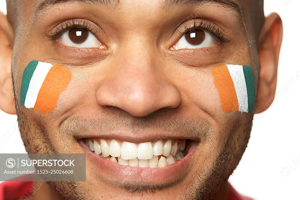 Young Male Sports Fan With Ivory Coast Flag Painted On Face