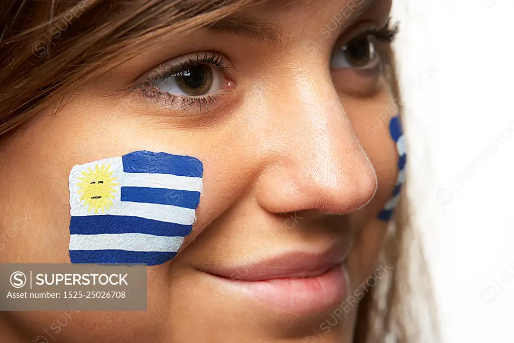 Young Female Sports Fan With Uruguayan Flag Painted On Face