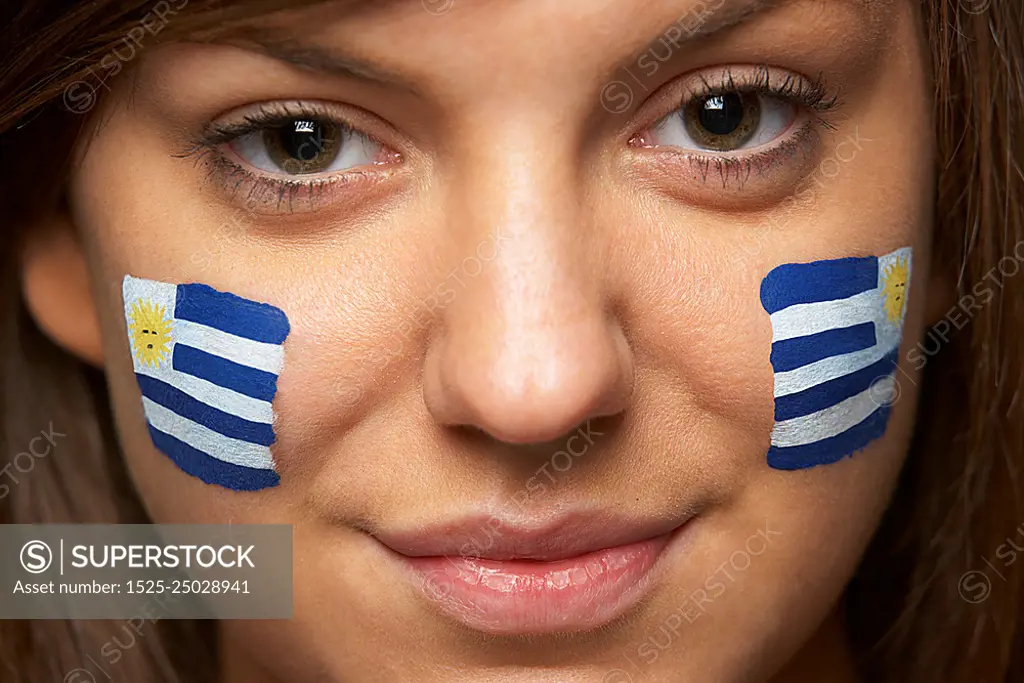 Young Female Sports Fan With Uruguayan Flag Painted On Face