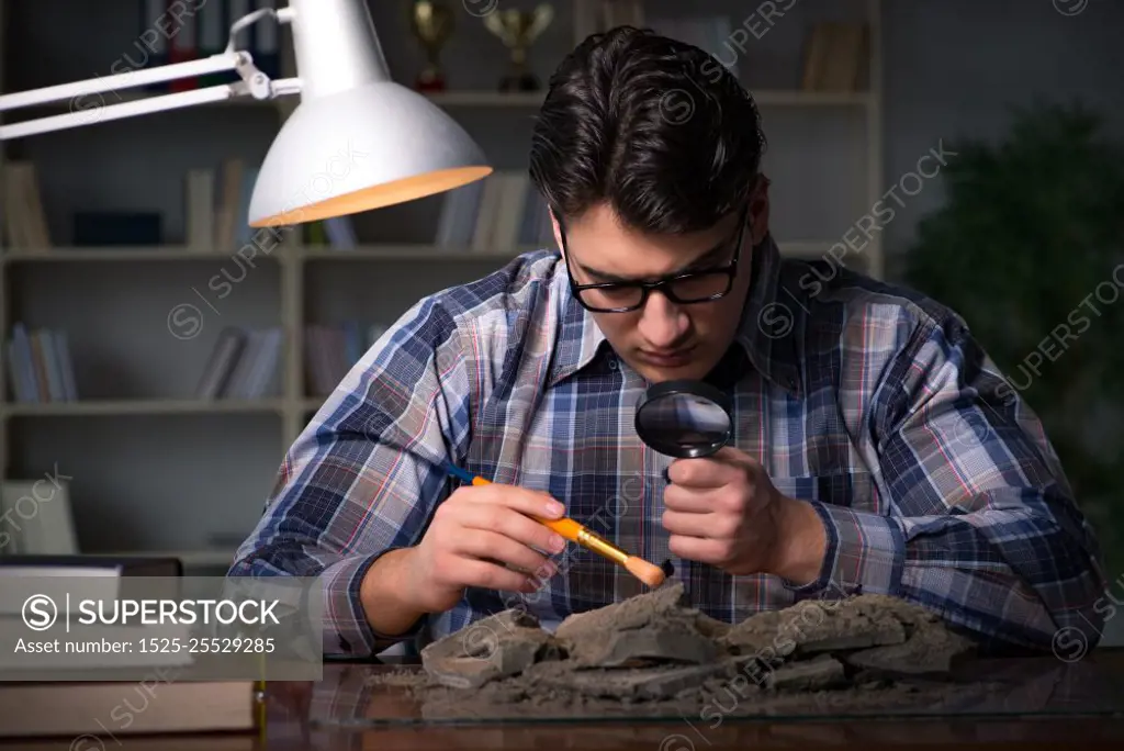 Archeologist working late night in office