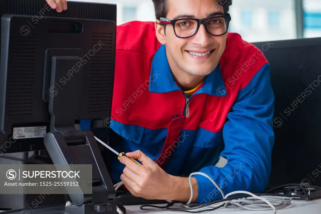 Computer repairman working on repairing computer in IT workshop. The computer repairman working on repairing computer in it workshop