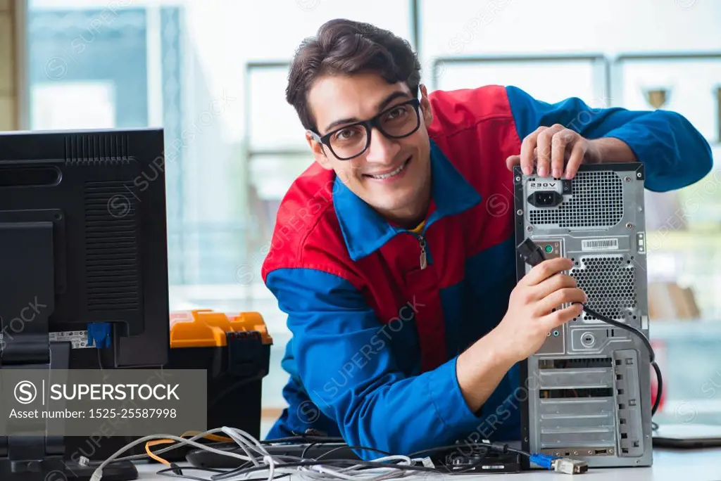 Computer repairman working on repairing computer in IT workshop. The computer repairman working on repairing computer in it workshop