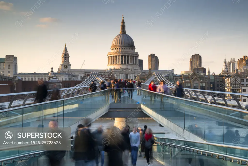 St Pauls Cathedral and the Millennium Bridge landscape with blur. England, London, City of London. St Pauls Cathedral and the Millennium Bridge at sunset.. St Pauls Cathedral and the Millennium Bridge at sunset landscape with blurred tourists