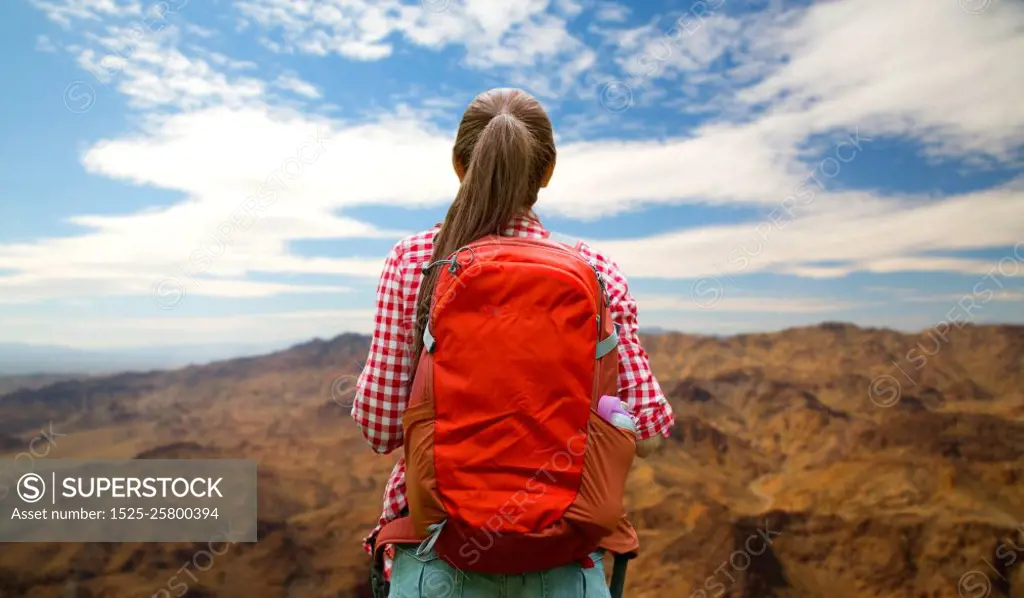 travel, tourism and hike concept - young woman with backpack over grand canyon national park hills background. woman with backpack over grand canyon hills. woman with backpack over grand canyon hills