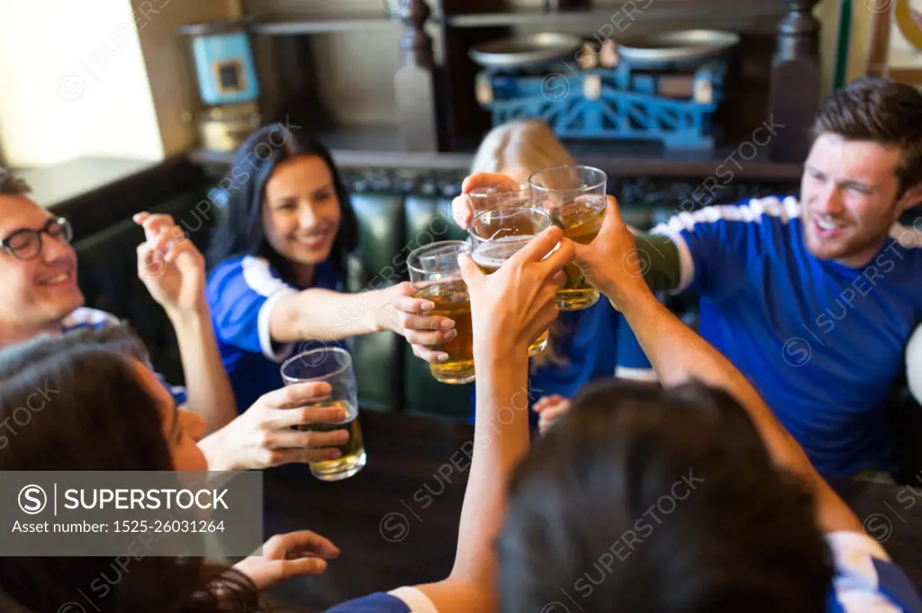 sport, soccer, people and leisure concept - happy friends or football fans clinking beer glasses at bar or pub. football fans clinking beer glasses at sport bar. football fans clinking beer glasses at sport bar