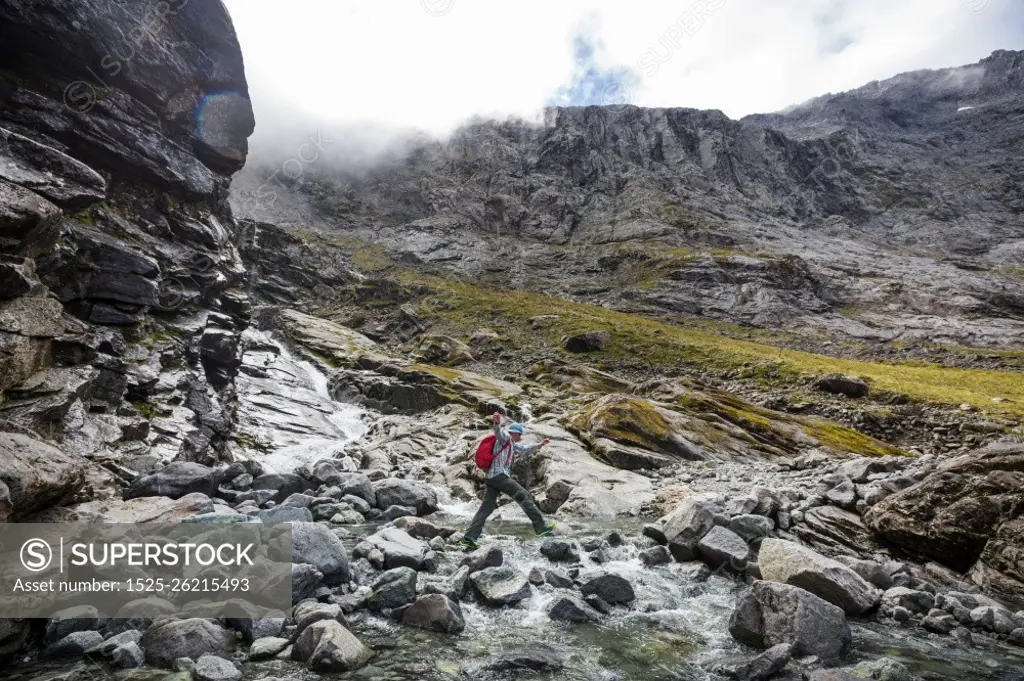 Man walking on hike trail route with Mount Cook National Park, beautiful mountains region. Tramping, hiking, travel in New Zealand.