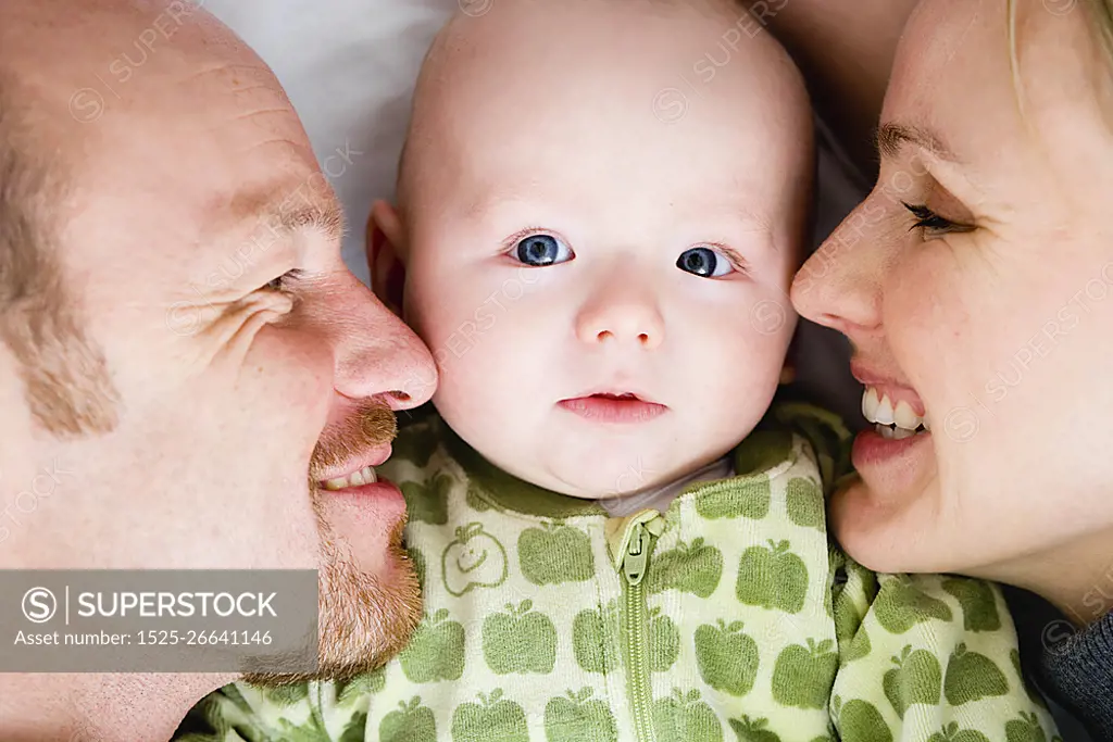 Baby laying between dad and mom