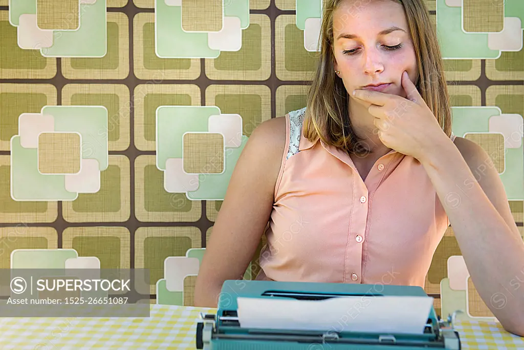 Adolescent girl sitting with typewriter