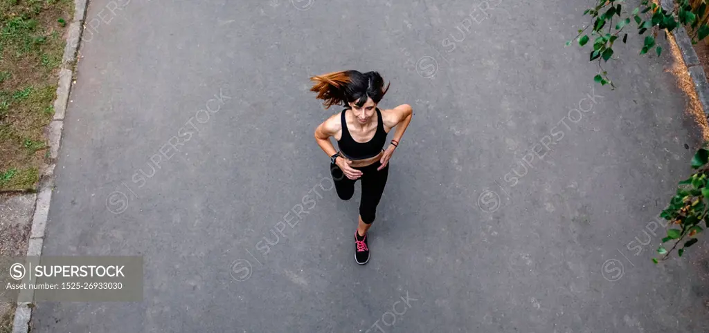 Aerial view of female athlete running on a road