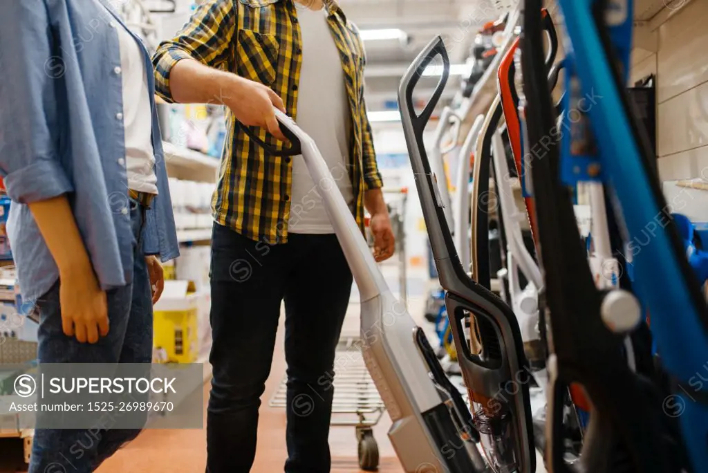 Male person hand holds vacuum cleaner in electronics store. Man buying home electrical appliances in market. Male hand holds vacuum cleaner, electronics store