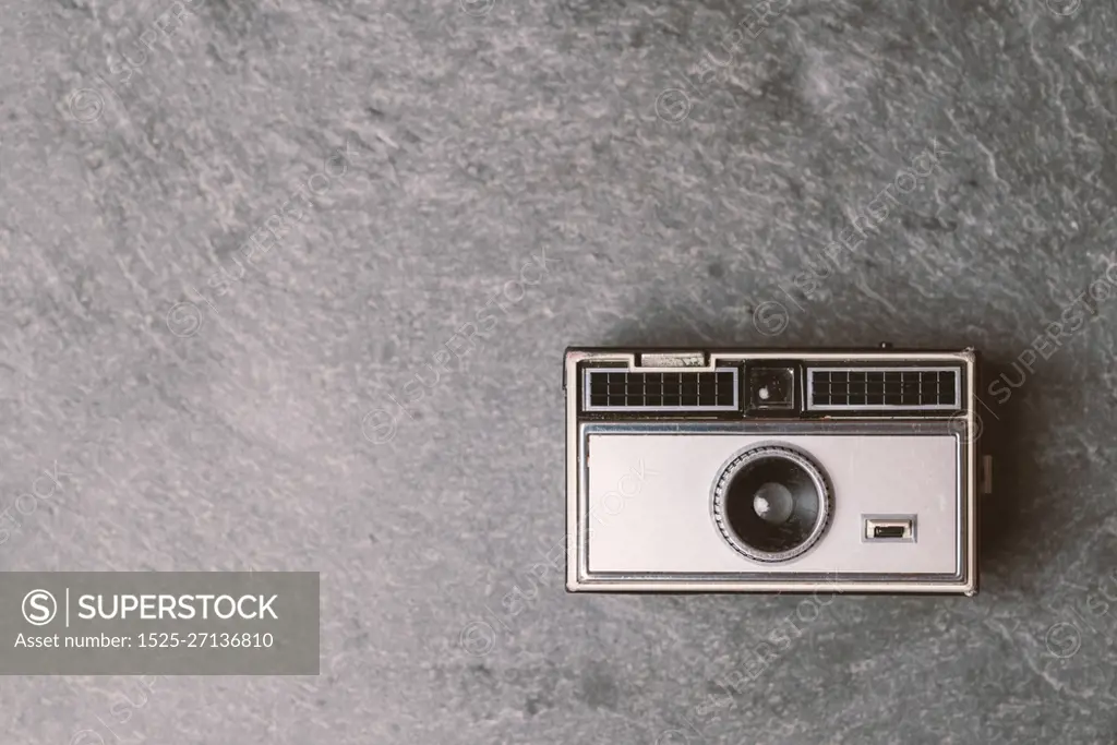 Retro classic 35mm photo camera on gray stone Background