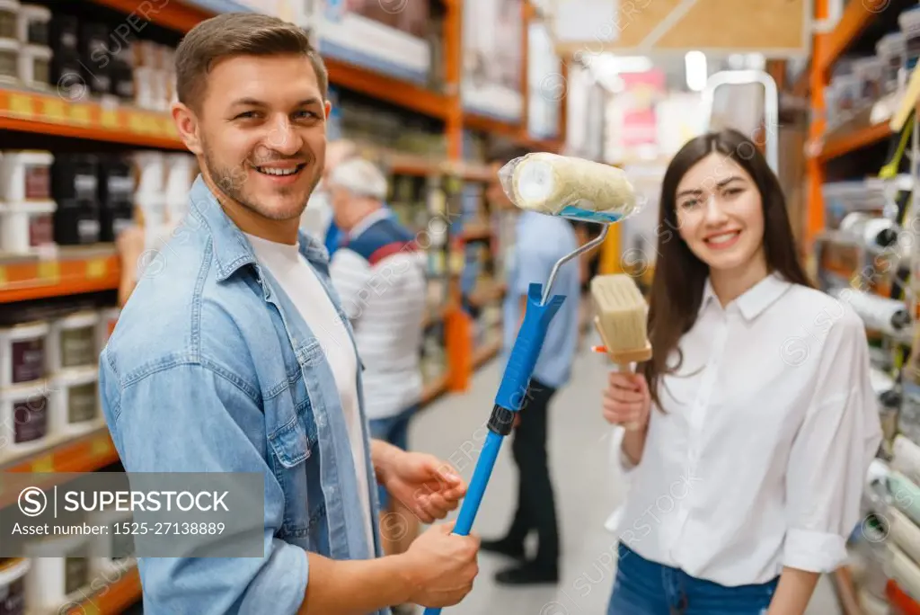 Young couple buying repair tools in hardware store. Male and female customers look at the goods in diy shop