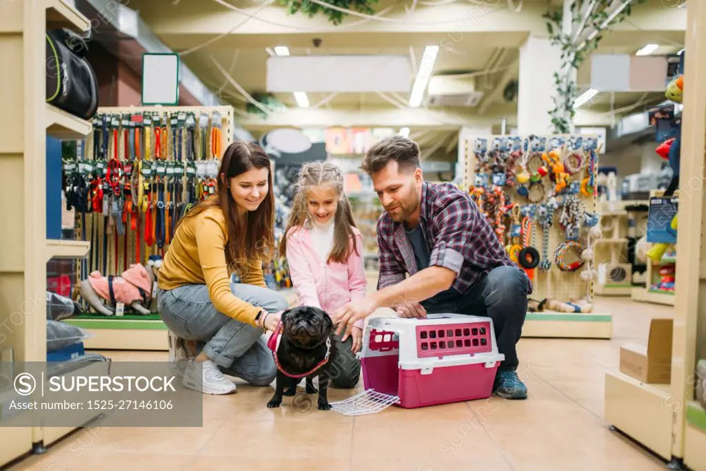 Family buying supplies for little puppy in petshop. Father, mother and dauther chooses accessories for dog in pet shop. Family buying supplies for little puppy in petshop