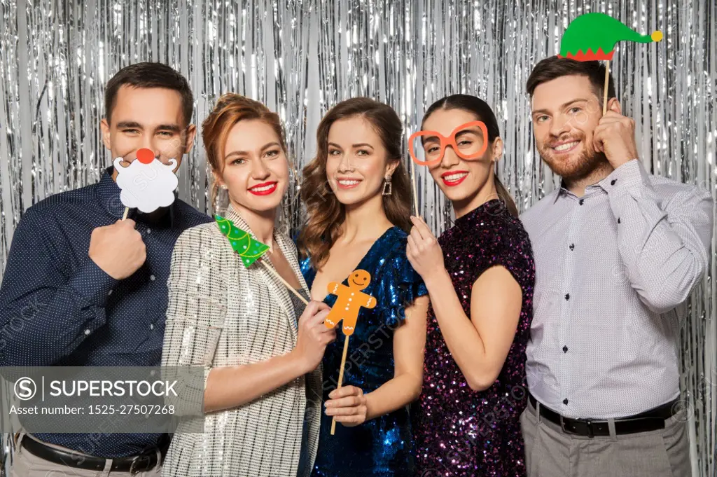 celebration, christmas and holiday concept - happy friends posing with party props. happy friends posing with christmas party props