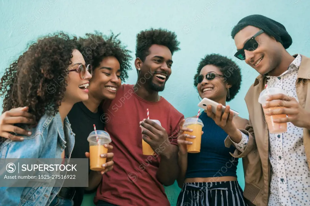 Portrait of afro friends having fun together and enjoying good time while drinking fresh fruit juice. 