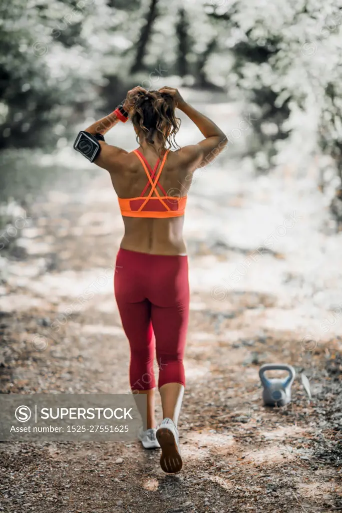 Outdoor exercising. Female athlete exercising in the park.